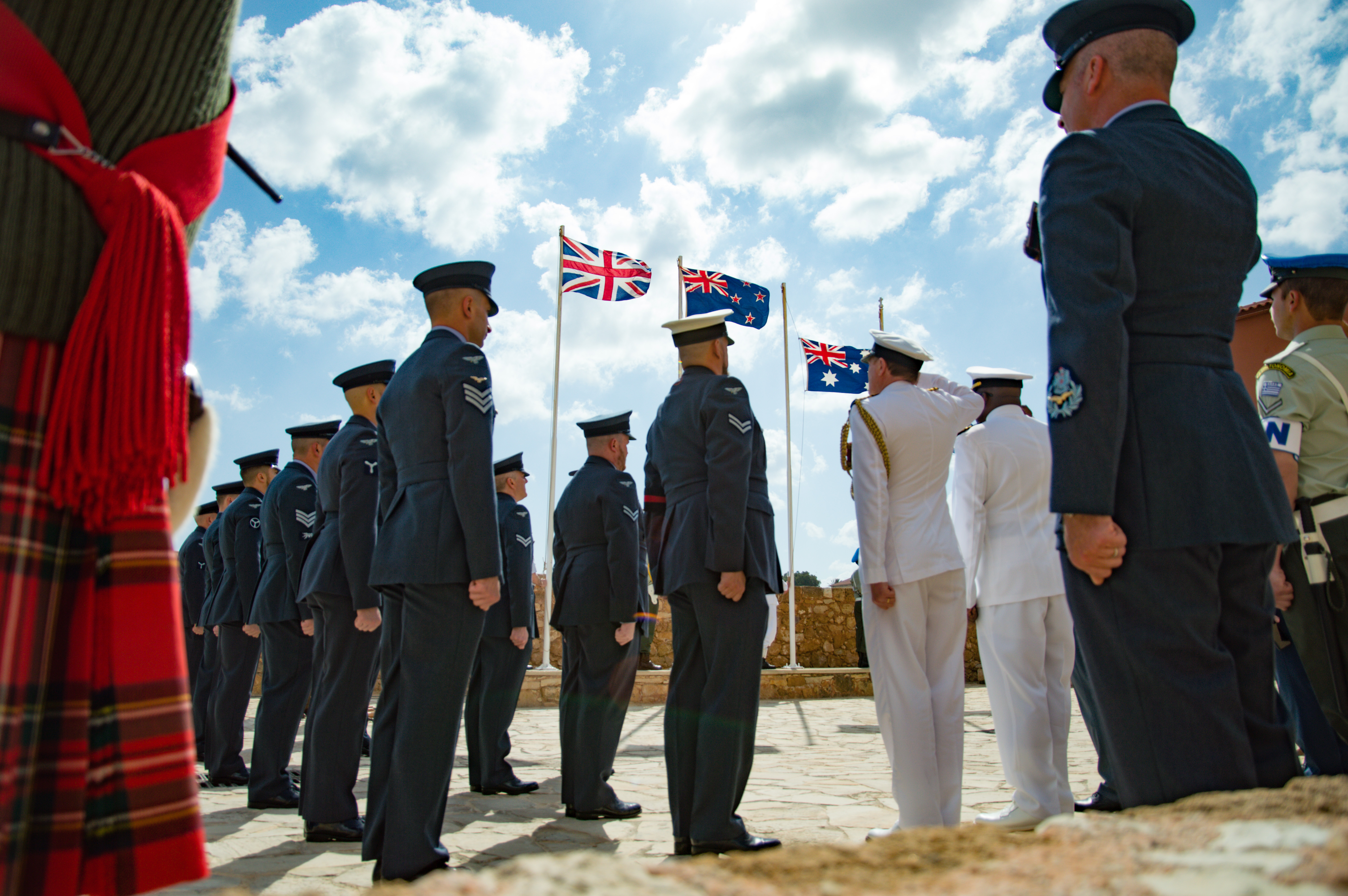 Personnel stand in parade saluting.
